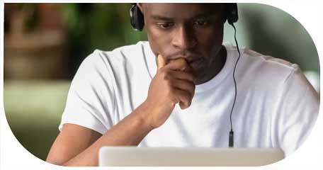 image for talent assessment in customer centric recruitment showing young man with earphones on concentrating on his computer